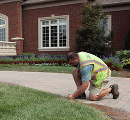 a Mississauga sprinkler repair tech is adjusting a sprinkler head